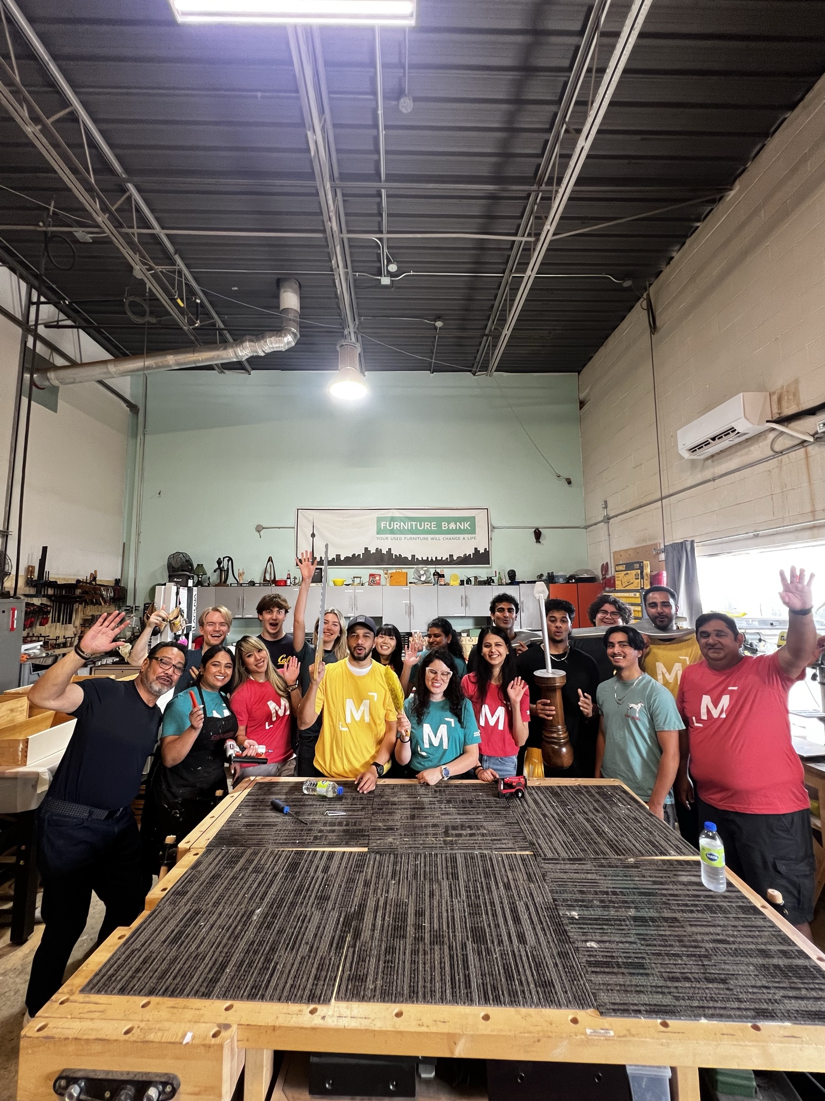 Syed Najam with a diverse volunteer team in the Furniture Bank workshop