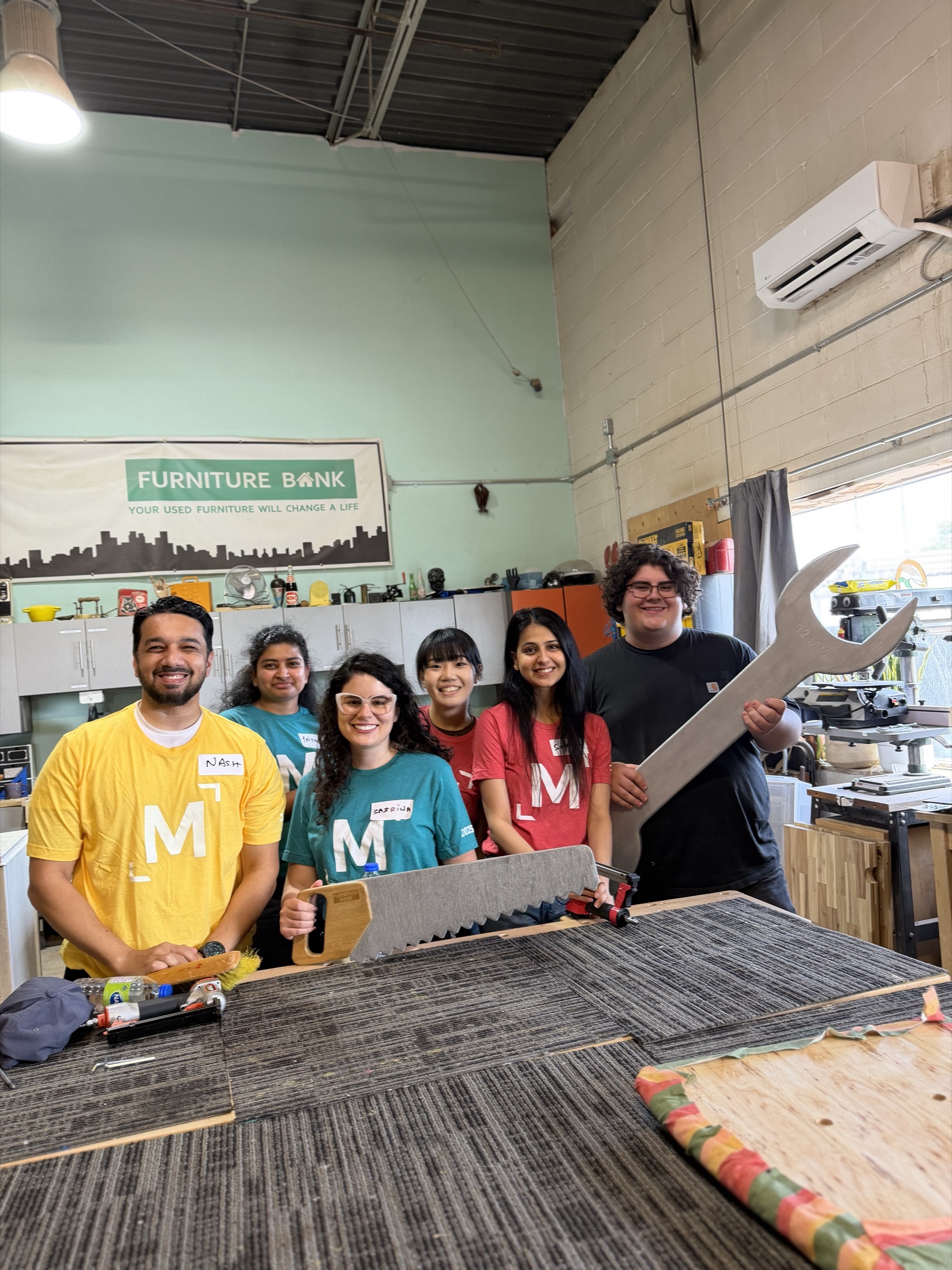Syed Najam and volunteers working together inside the Furniture Bank workshop